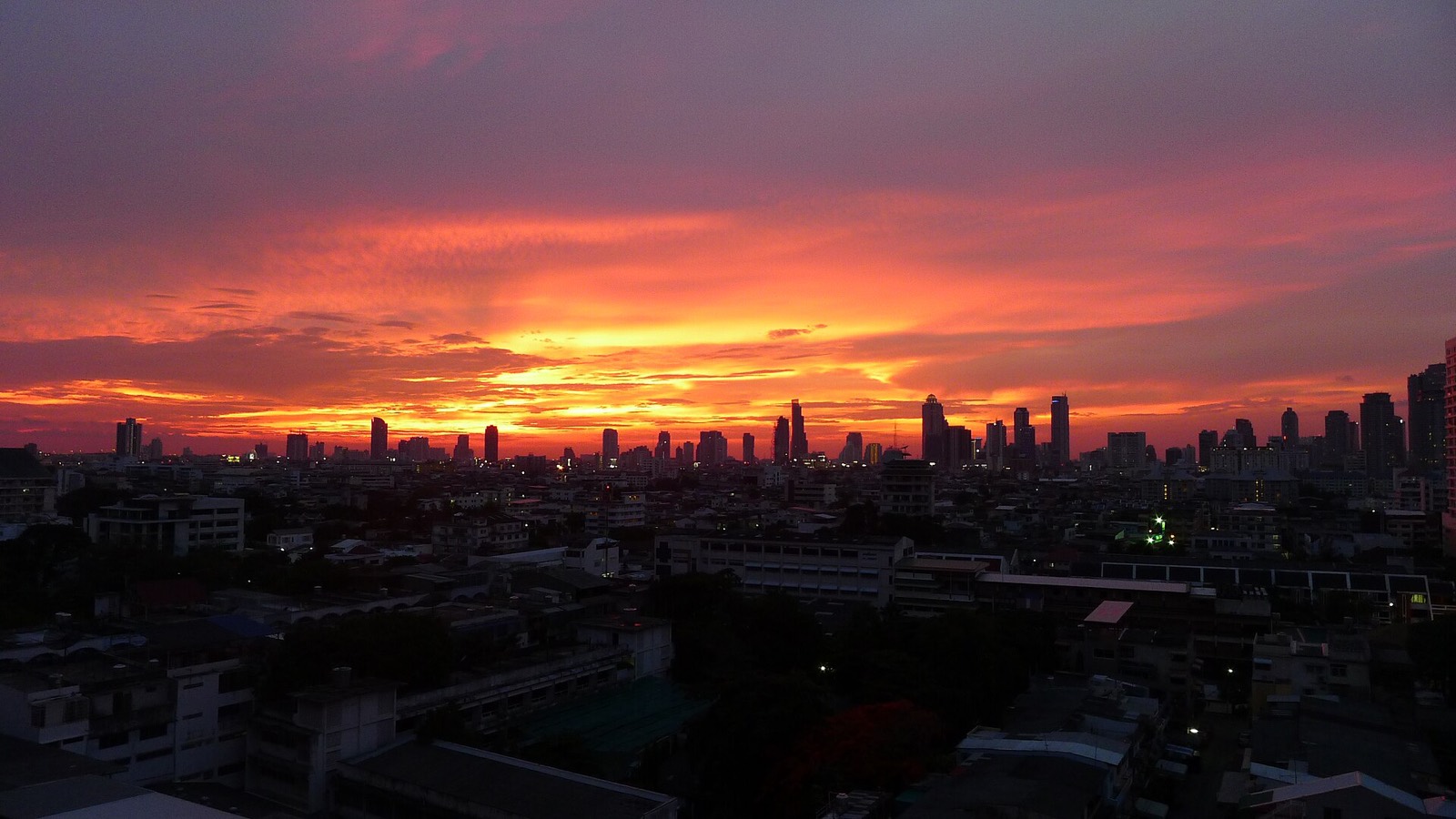 Sunset over the Bangkok skyline from a rooftop
